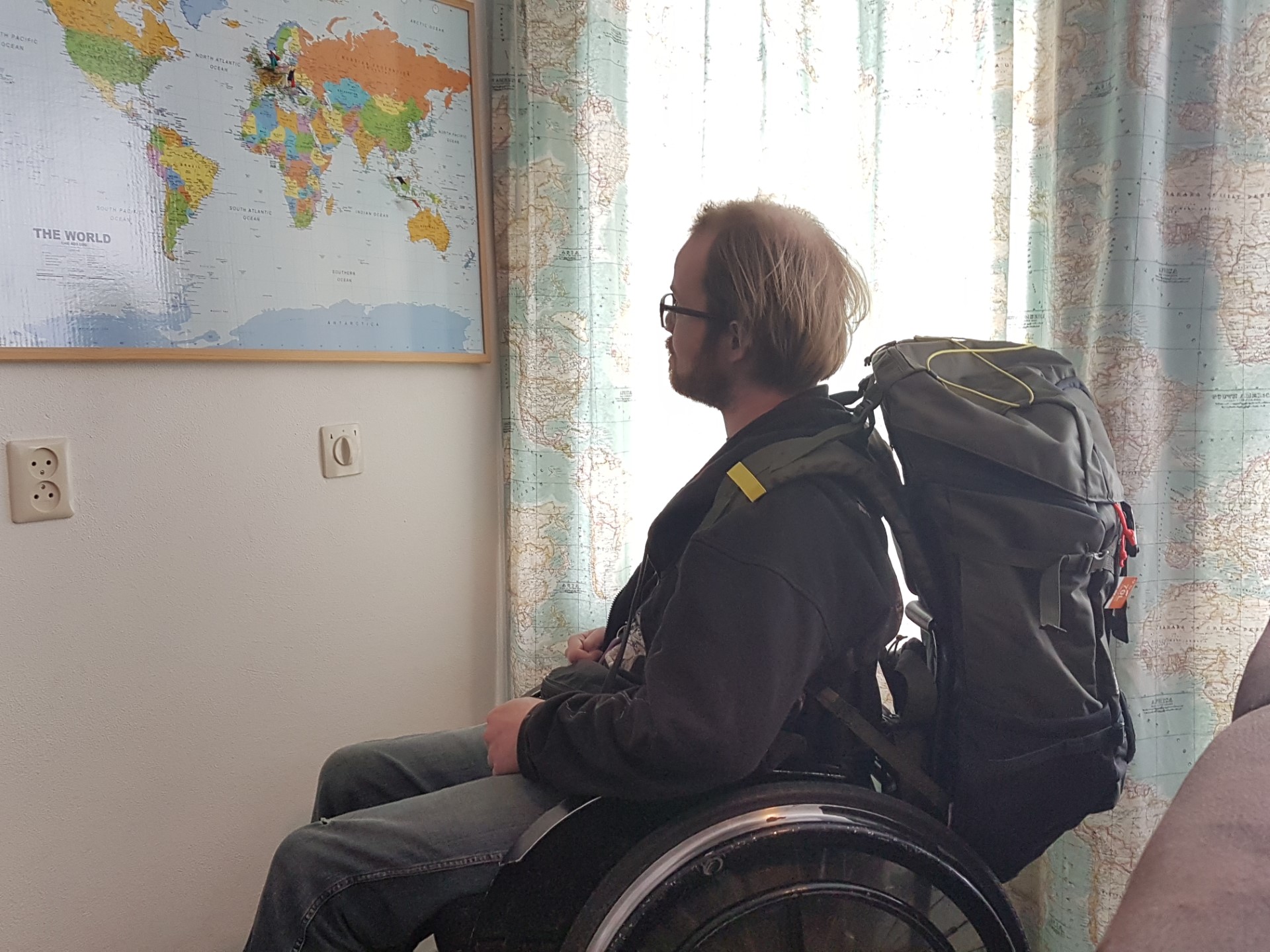 afbeelding van Bob die in een rolstoel zit en naar een wereldkaart kijkt